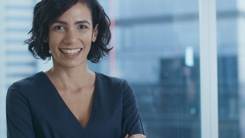 Portrait of the Successful Businesswoman Crossing Her Arms and Smiling. Beautiful Female Executive Standing in Her Office. Shot on RED EPIC-W 8K Helium Cinema Camera.