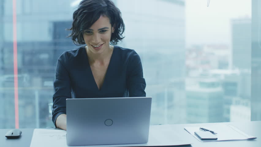 Beautiful Businesswoman Sitting at Her Office Desk, Raising Her Arms and Applauds in Celebration of a Successful Job Promotion. Shot on RED EPIC-W 8K Helium Cinema Camera. Royalty-Free Stock Footage #1016145946