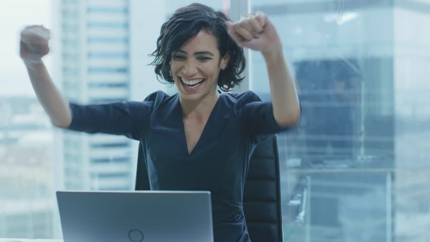Beautiful Businesswoman Sitting at Her Office Desk, Raising Her Arms and Applauds in Celebration of a Successful Job Promotion. Shot on RED EPIC-W 8K Helium Cinema Camera. | Shutterstock HD Video #1016145946
