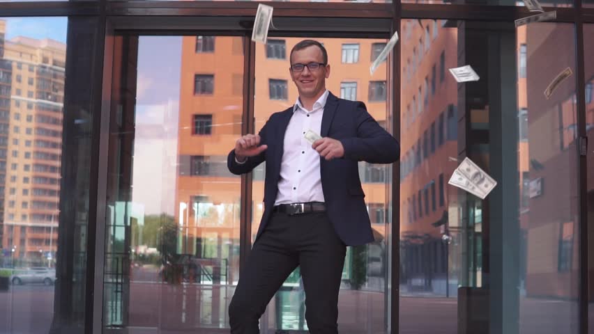 Rich attractive Businessman in glasses picks up money and rejoices. slow motion Royalty-Free Stock Footage #1016148790