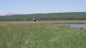 Fly-fisherman walking by the river of Montana state