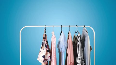 Women's clothing on a white clothes hanger on blue pastel background.