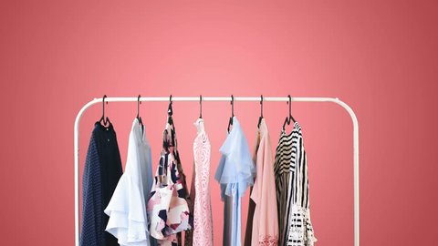Women's clothing on a white clothes hanger on pink pastel background.
