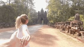 Follow me to discover the ancient temples, young woman leading man to the main gate of temples entrance; people travel togetherness concept 
Slow motion