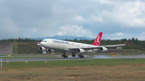 Oslo Airport Norway - ca September 2018: airplane turkish airlines huge airbus a340 landing on runway panning left ambient sound panning left