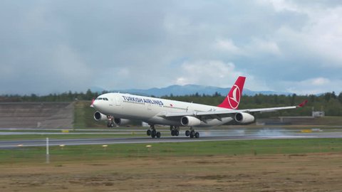 Oslo Airport Norway - ca September 2018: airplane turkish airlines huge airbus a340 landing on runway slow motion panning left