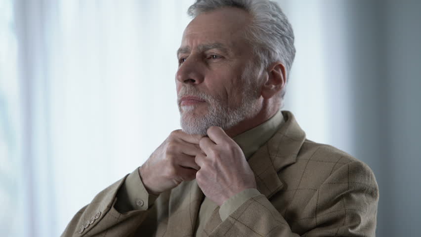 Insecure senior man dressing up, looks doubtful, fitting jacket in atelier | Shutterstock HD Video #1016162317