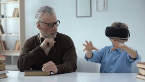 Amazed grandfather looking at grandson in vr headset, future innovations