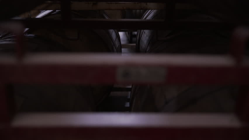 Tilt up shot of wooden barrels on racks at brewery