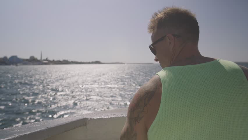 View from the back of a man standing on the stern of the ship.