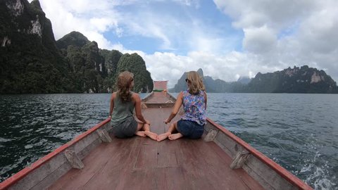 Two happy woman traveling by boat and enjoying the sun. Koh Hong, Thailand