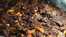Pouring chocolate on cake with nuts, Tasty, thick and very dark chocolate used as dressing for freshly baked cake on cake sheet. Some interesting bright reflections on surface of chocolate. - Powered by Shutterstock - Get 15% off with code: PIKWIZARD15