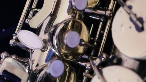 Details of a golden saxophone. A wind instrument seen very close to the camera.