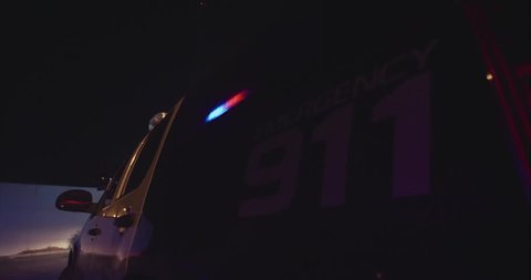 side of police car with emergency 911 text lights on