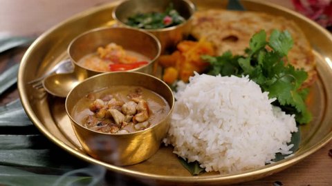 Assorted indian sri-lanka food set on wooden background. Dishes and appetisers of indeed cuisine, rice, lentils, paneer, samosa, spices, masala. Bowls and plates with indian food top view chicken