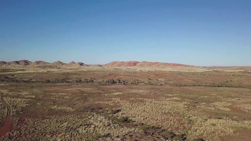 Flying towards vast country plains and mountain ranges at Marble Bar in Western Australia
