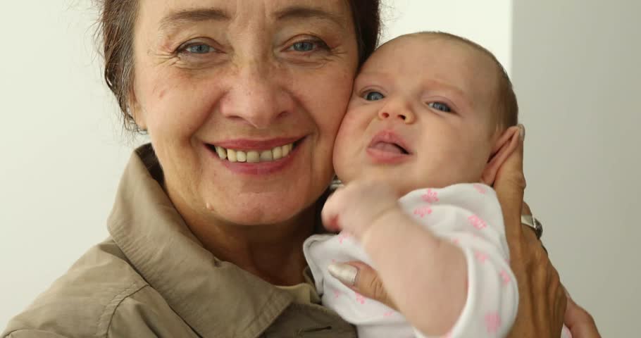 Grandmother Holding Newborn Baby Granddaughter indoores white background | Shutterstock HD Video #1016182663