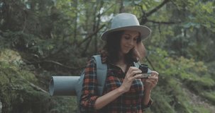 Hiker girl backpacker takes photographs of the mountain forest. 4K video shooting by handheld gimbal