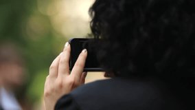 Woman taking pictures on smartphone, seizing moments of happiness, happy life