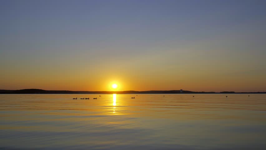 A girl is walking on the water at sunset