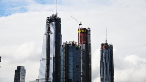 Time Lapse skyscrapers under construction against moving clouds. Manhattan, New York City, USA