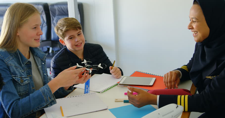 Female pilot about model drone to kids in training institute 4k