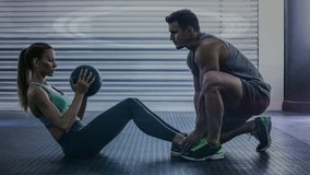 Digitally composite video of trainer assisting woman in exercising against interface