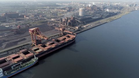 Bulk Carrier Ship Docked in an Industrial Port Offloading Raw Materials and Cargo
