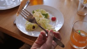 the girl is eating a salad in the first person cafe. slow motion video. salad of chicken breast, white cabbage, and parsley seasoned with mayonnaise lemon juice sauce and decorated with croutons and