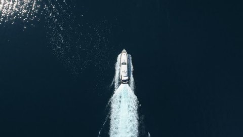 Aerial - Top down view of luxury motor boat racing on the water
