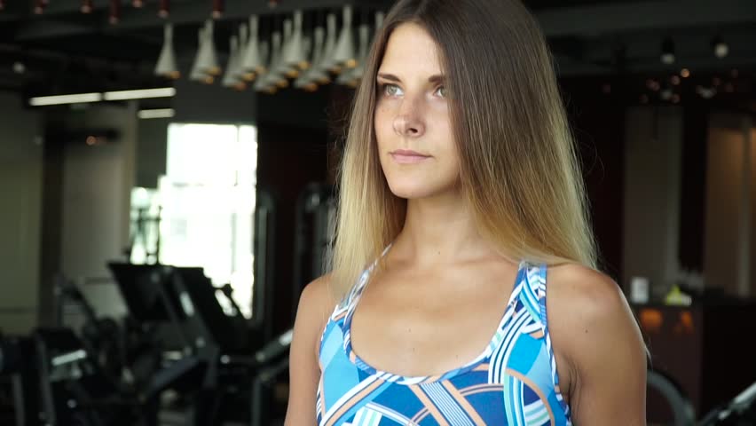 Attractive girl running on the treadmill in the gym . Full face portrait