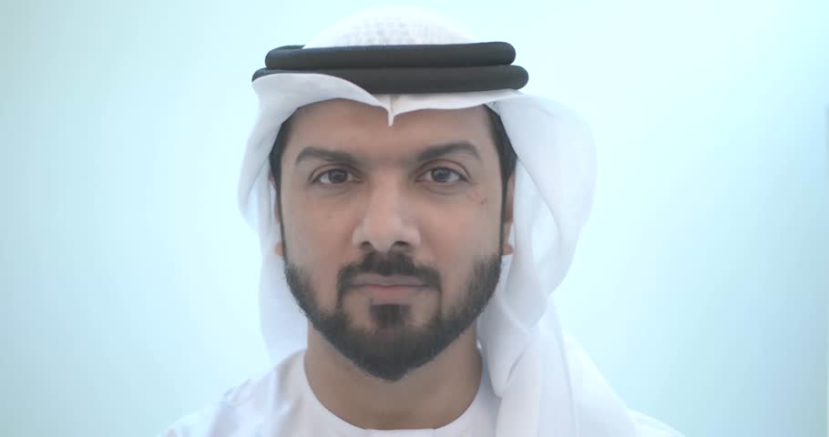 Smiling man wearing traditional emirates clothes, in dubai. studio footage with different poses