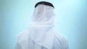 Smiling man wearing traditional emirates clothes, in dubai. studio footage with different poses