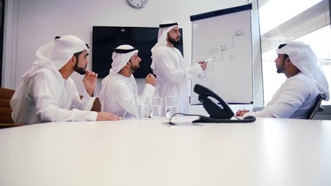 Four businessmen in dubai working in their office, planning the future development of the company