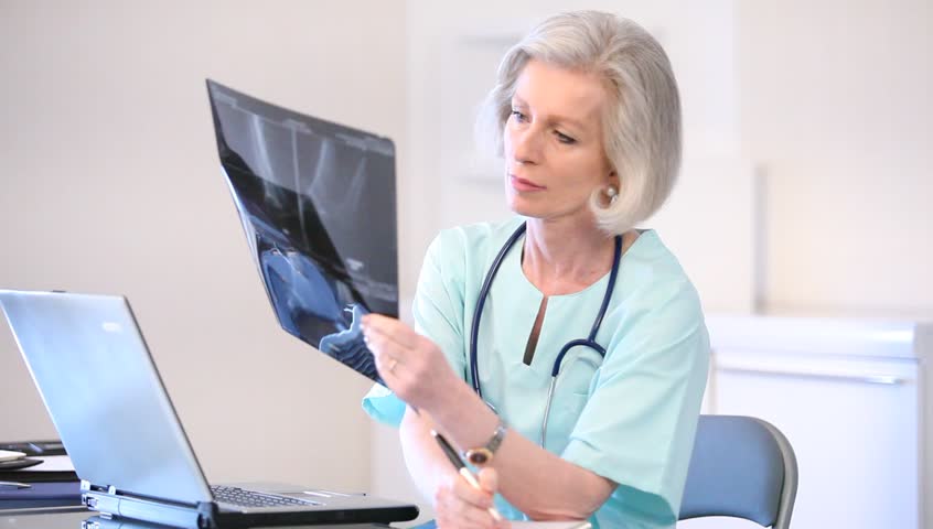 Senior nurse looking at x-ray in the office Royalty-Free Stock Footage #1016233