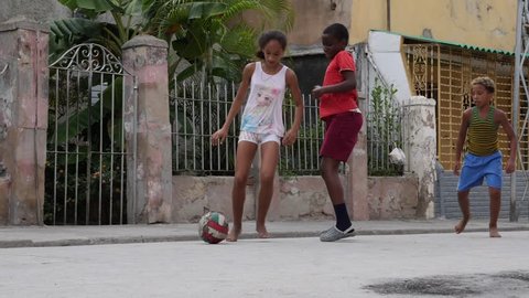 Santiago de Cuba / Cuba - July 17 2018: Poor Kids Play Football Soccer On The Old Street Santiago de Cuba