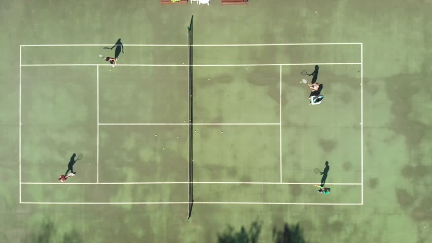 Young Girl and boy athletes playing tennis outdoor aerial vertical shot | Shutterstock HD Video #1016240797