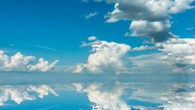 futuristic background consisting of Time lapse clip of white fluffy clouds over blue sky and their reflection, video loop