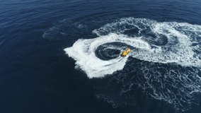 Aerial shot of young man riding on a watercraft. Watercraft cruising at sea