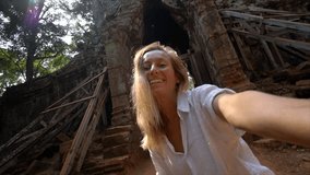 Travel woman taking selfie portrait in front of temple's complex gate; young people traveling Asia wonderlust concept
Slow motion video