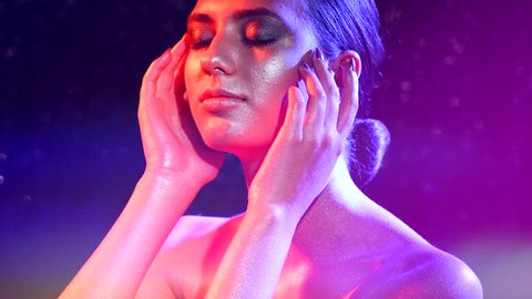 High Fashion model girl in colorful bright sparkles on skin and neon lights posing, portrait of beautiful woman, trendy glowing face, body make-up. Art design colorful make up. Glitter Vivid makeup 4K