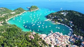 Aerial drone bird's eye view video of iconic small port and fishing village of Lakka with traditional Ionian architecture and sail boats docked, Paxos island, Ionian, Greece