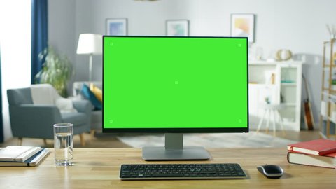 Zoom in On a Modern Personal Computer with Mock-up Green Screen Display Standing on the Desk of the Cozy Home Office. Living Room Created by Interior Designer with Good Taste and Style.