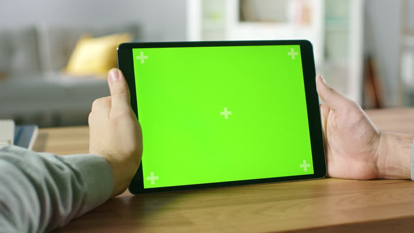 First Person Shot of a Man Using Green Mock-up Screen Digital Tablet Computer in Landscape Mode while Sitting at His Desk. In the Background Cozy Living Room. Shot on RED EPIC-W 8K Helium Camera. Royalty-Free Stock Footage #1016261944