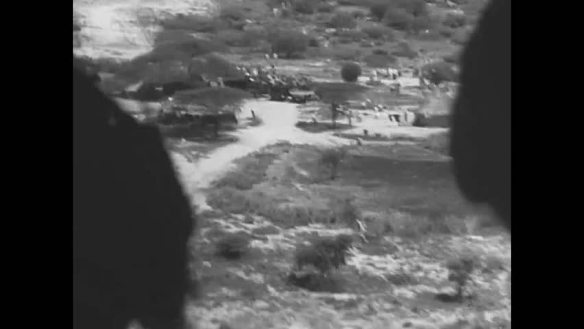 CIRCA 1950s - Observers watch as paratroopers parachute out of Military Air Transport Service aircraft onto a field during an exercise.