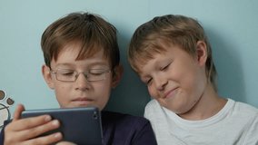 Two cute boys playing video game with smart phone indoors, Close-up, 4k shot
