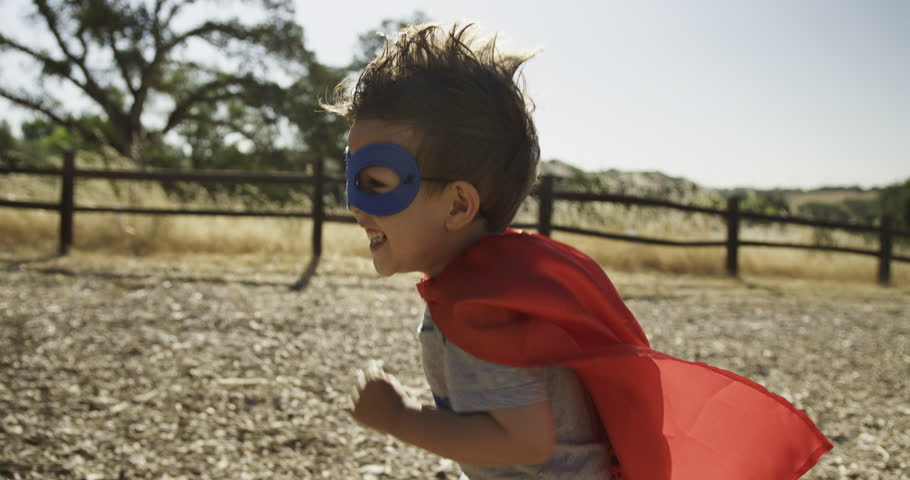Little boy wearing a red cape and blue mask, playing superhero 4k, slow motion, stock footage,  Royalty-Free Stock Footage #1016276659