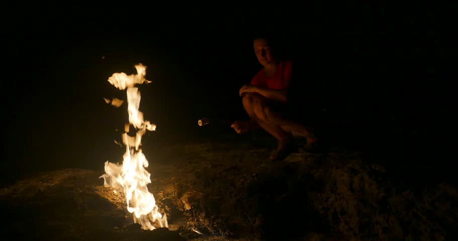 Youg woman roast marshmallow on fire
