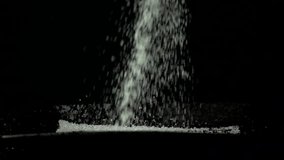 pile sugar on black background, slow motion