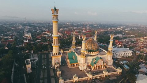 Yellow Mosque (Habbul Wathan Mosque) in Indonesia, Aerial drone view Mosque Sunny day, blue sky, sunset. Indonesia part of the city, downtown, beautiful mosque in the world